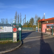 Entrée d'une déchetterie avec un portail métallique vert