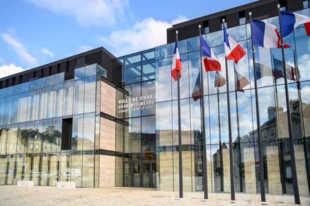 Façade de l'hôtel de Ville avec l'entrée principale et les drapeaux