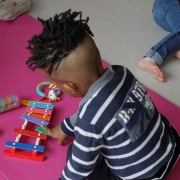 Un jeune enfant qui joue avec un xylophone en bois dans un établissement petite enfance